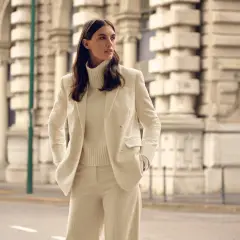 Elegantes cremefarbenes Cord-Outfit: Was zieht man zur Einschulung an als Gast? Ein schicker Hosenanzug mit Rollkragenpullover.