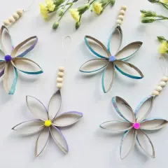 Blumen aus Klopapierrollen: basteln mit Klopapierrollen einfach. Bunte Blüten mit Holzperlen und Pompons, daneben gelbe Blumen.
