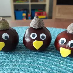 Drei lustige Kastanien-Figuren mit Eichelkappen und Wackelaugen, ein Beispiel für einfaches Kastanien basteln.