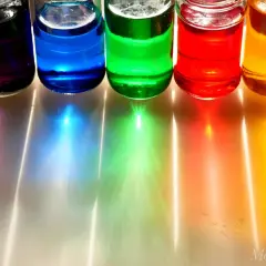Fünf Gläser mit bunten Flüssigkeiten: lila, blau, grün, rot und gelb. Kinder lieben es, mit diesen Farben zu experimentieren und neue Farbtöne zu kreieren.