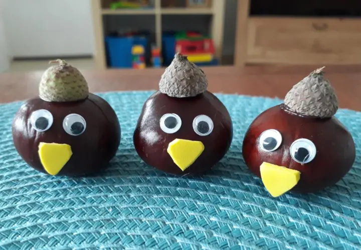 Drei lustige Kastanien-Figuren mit Eichelkappen und Wackelaugen, ein Beispiel für einfaches Kastanien basteln.