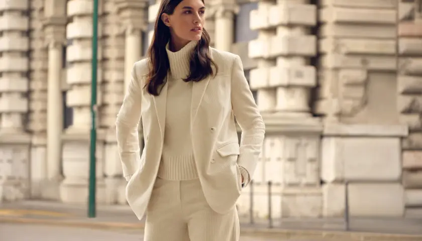 Elegantes cremefarbenes Cord-Outfit: Was zieht man zur Einschulung an als Gast? Ein schicker Hosenanzug mit Rollkragenpullover.