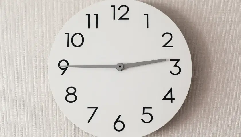 Ein schlichtes Zifferblatt zeigt dreiviertel 12. Wo sagt man das? In vielen Regionen Deutschlands, um 11:45 Uhr zu beschreiben.