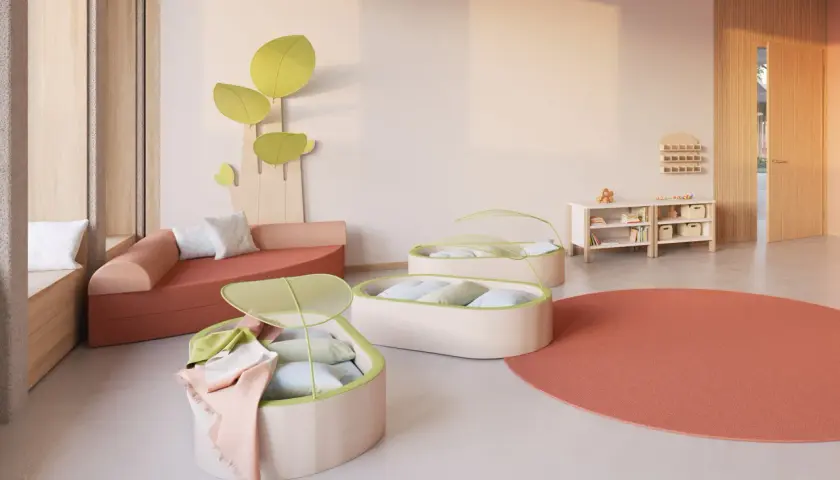 Gemütliche Raumgestaltung Kita mit Sitzlandschaft, Liegekojen und Spielzeugregalen.