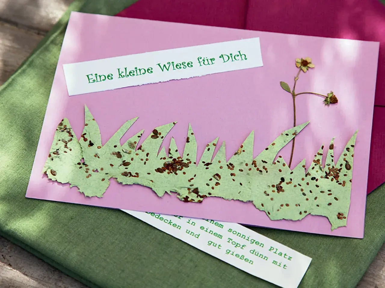 Eine Karte mit selbstgemachtem Samenpapier, das wie Gras aussieht. Darauf steht "Eine kleine Wiese für Dich".