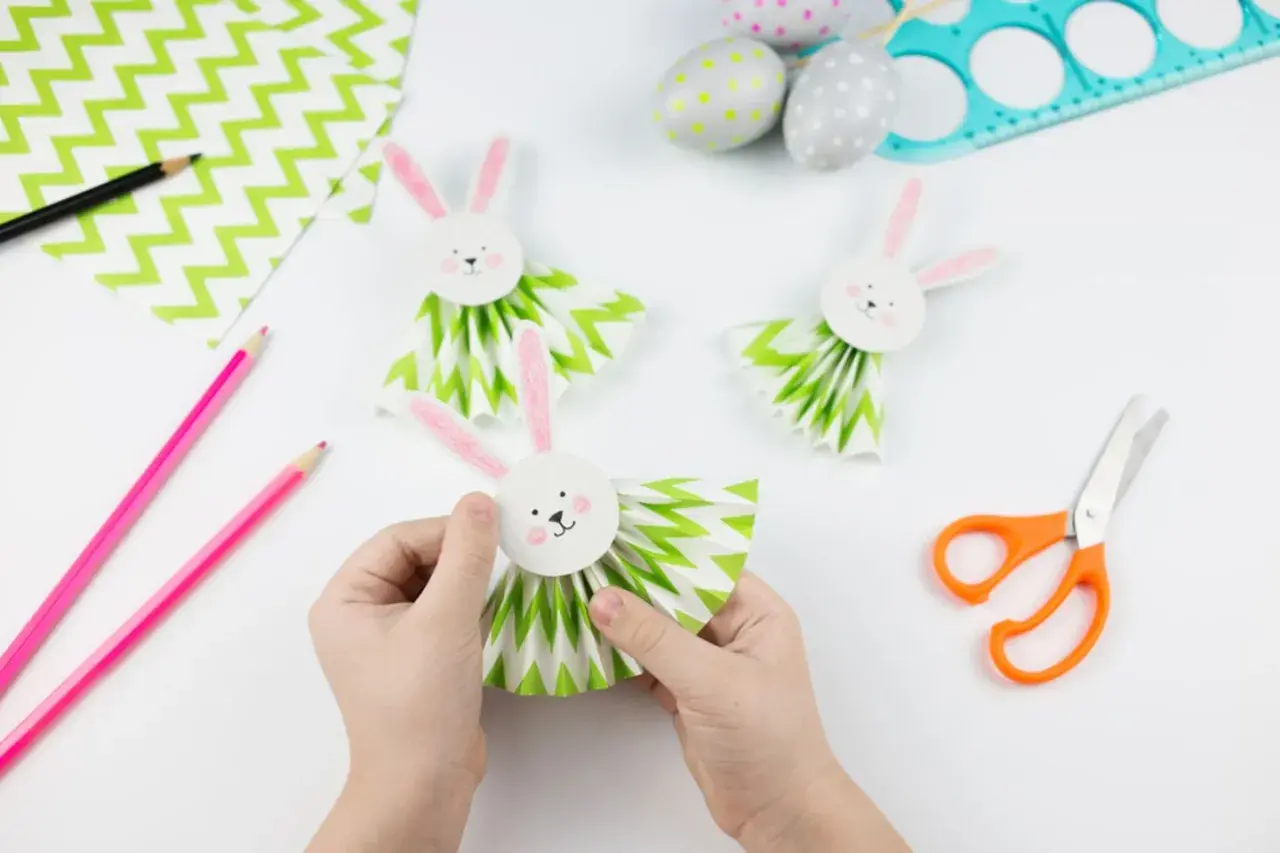 Osterbasteln mit Kindern Grundschule: Kleine Hände basteln süße Papierhasen mit Fächerkörpern. Bunte Ostern kann kommen!