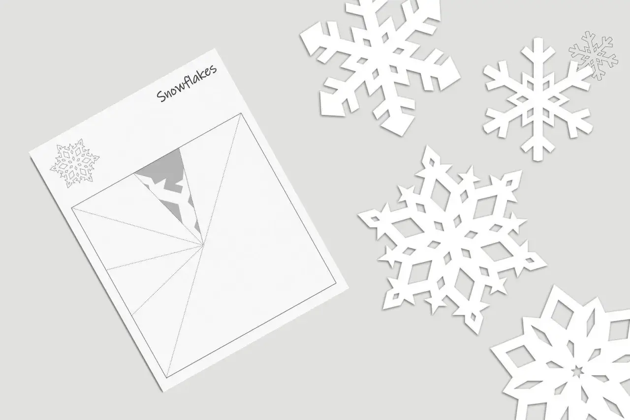 Schneeflocke vorlage einfach zum Ausschneiden. Papier gefaltet, bereit für den Schnitt. Mehrere fertige Schneeflocken liegen daneben.