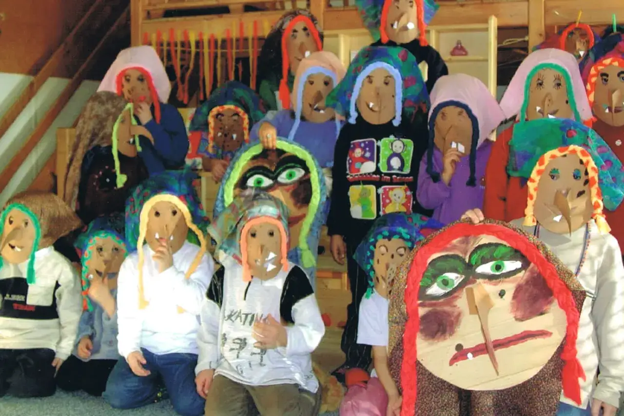 Kinder in selbstgebastelten Masken für den Fasching in der Kita. Bunte Kostüme und lustige Gesichter.